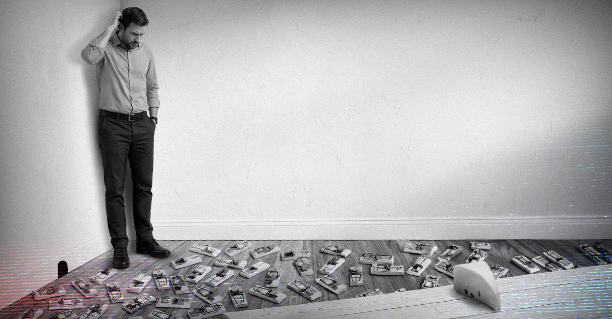 Man cornered in a room by a floor covered in mousetraps